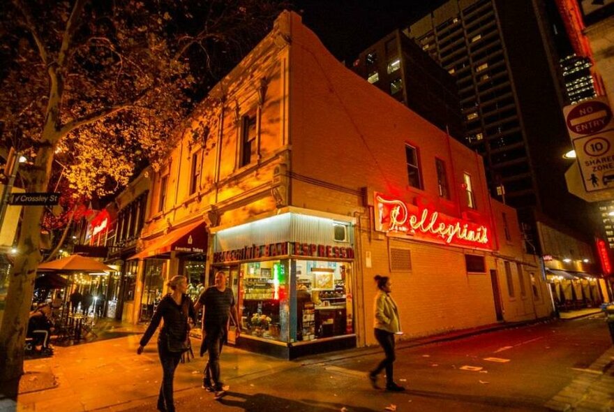 A corner restaurant with a red neon sign on the side