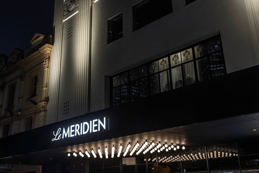 A night time photograph of the exterior of the Le Méridien hotel in Melbourne.