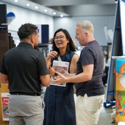 Three people looking at samples at a home expo.