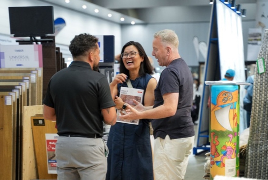 Three people looking at samples at a home expo.