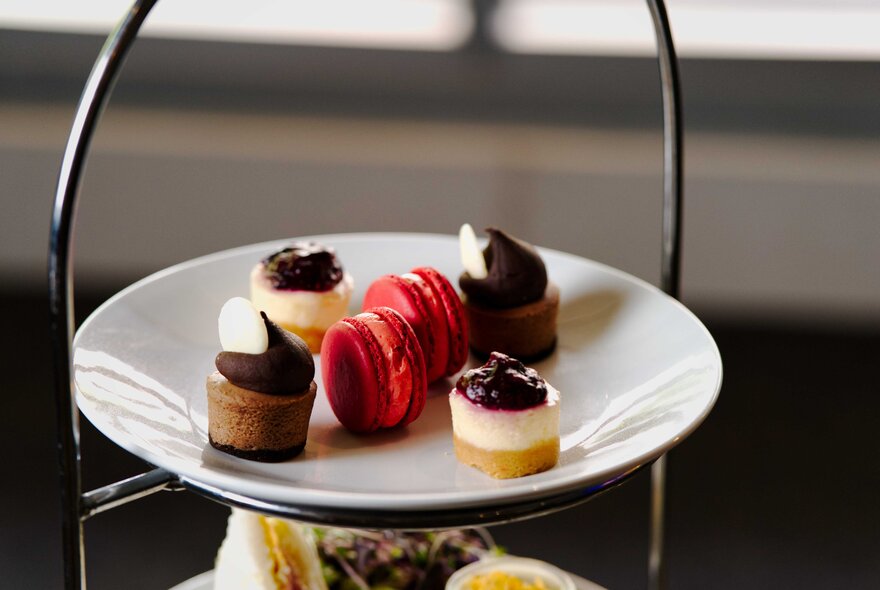 Two-tiers of a tiered serving tray with a selection of treats.