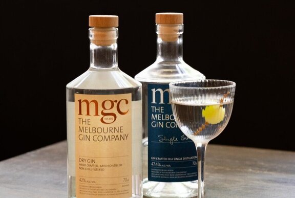Two bottles of Melbourne Gin Company gin with a martini in a small glass in the foreground.