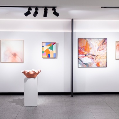 A gallery space featuring colouful artworks on the white walls.