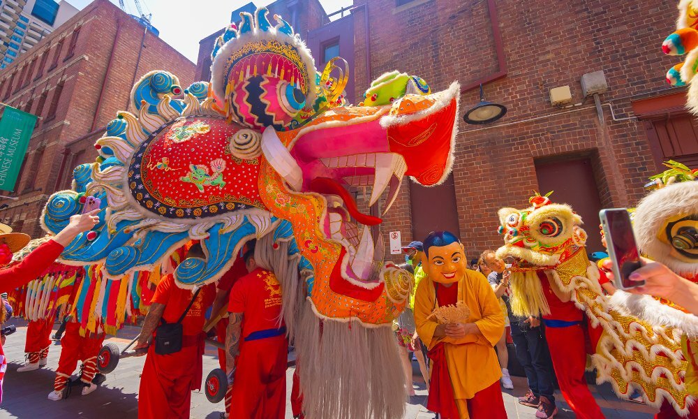 Performers in costumes carrying a giant dragon at a Lunar New Year celebration.