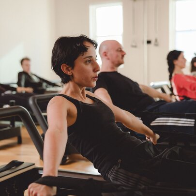 A reformer Pilates class in session. 
