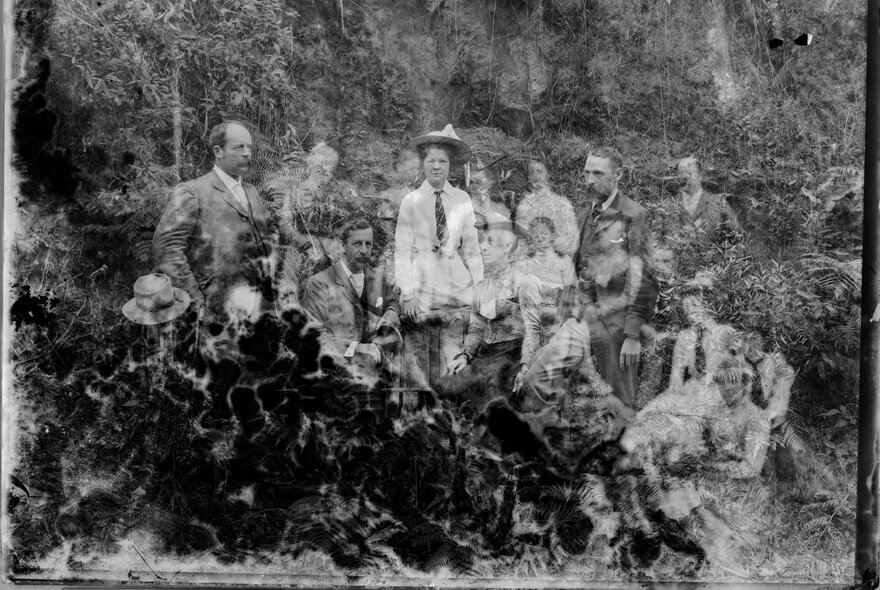A damaged black and white photo of a group of people circa 1900 in the bush in Australia.
