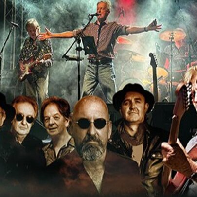 Men wearing sunglasses in front of a band performing on stage.