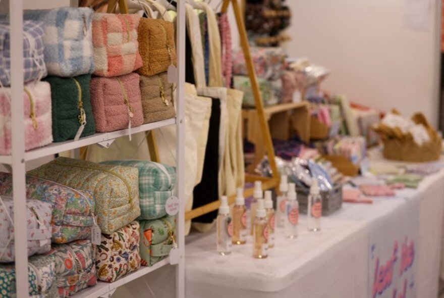 Market stall with floral-print bags and perfumes.