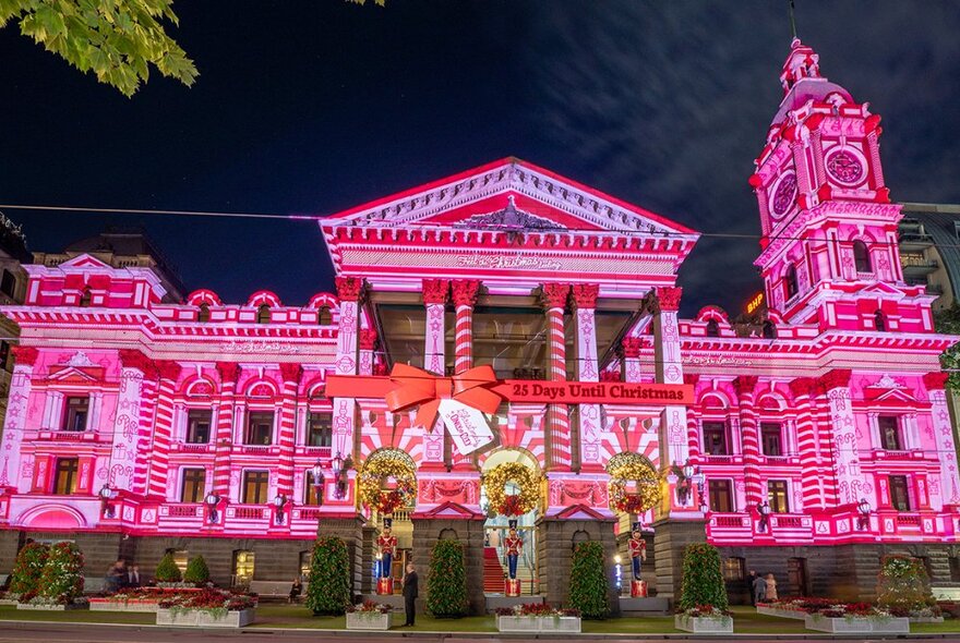 Pink and red Christmas lighting projections on the facade of Melbourne Town Hall