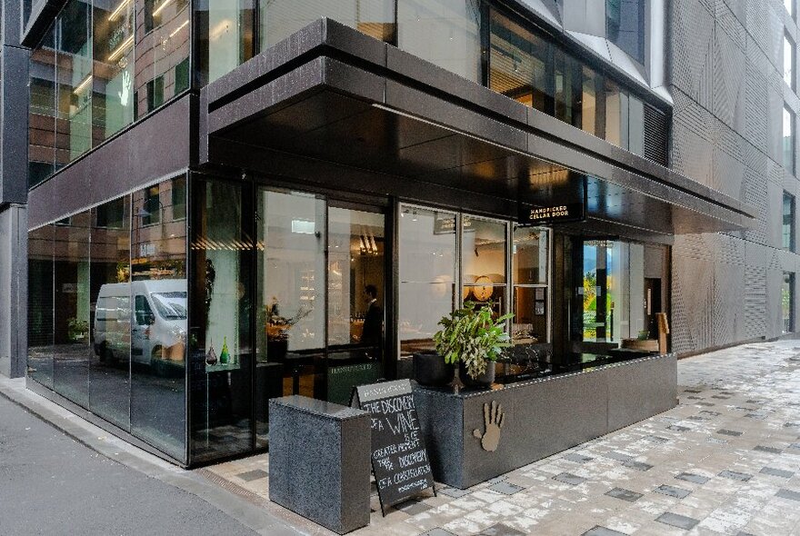 Sleek, black, modern exterior of Handpicked Wines store.