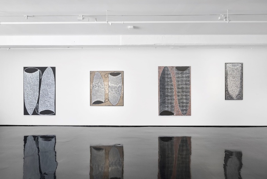 Four contemporary paintings hanging on a white wall in a gallery space.
