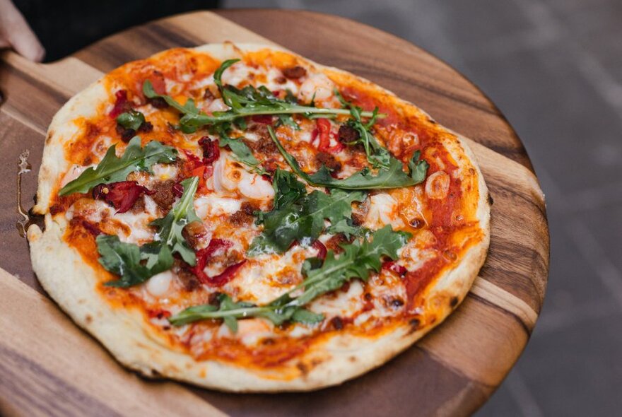 A wooden board topped with a pizza.