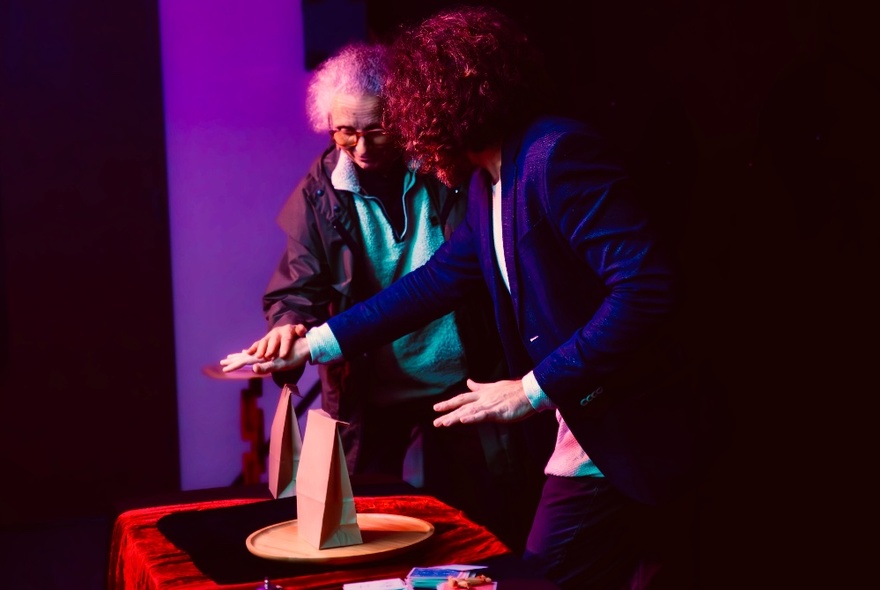 Two people performing a magic trick over small parcels. 