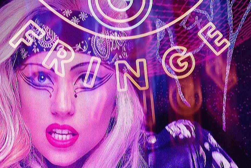 A blonde woman in dramatic eye makeup and bandana, behind neon lettering.