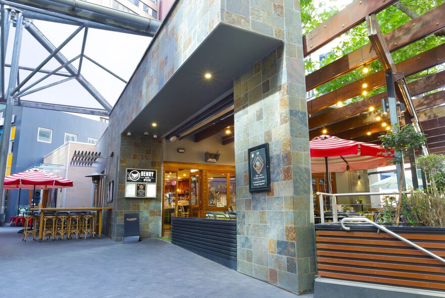 Restaurant foyer and outdoor dining tables with umbrellas.