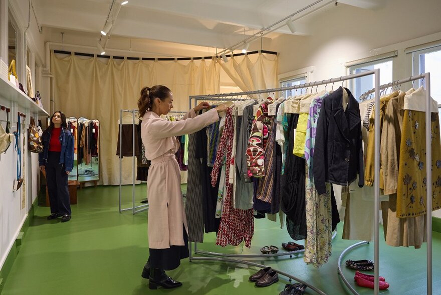 Two women are browsing at a clothing store