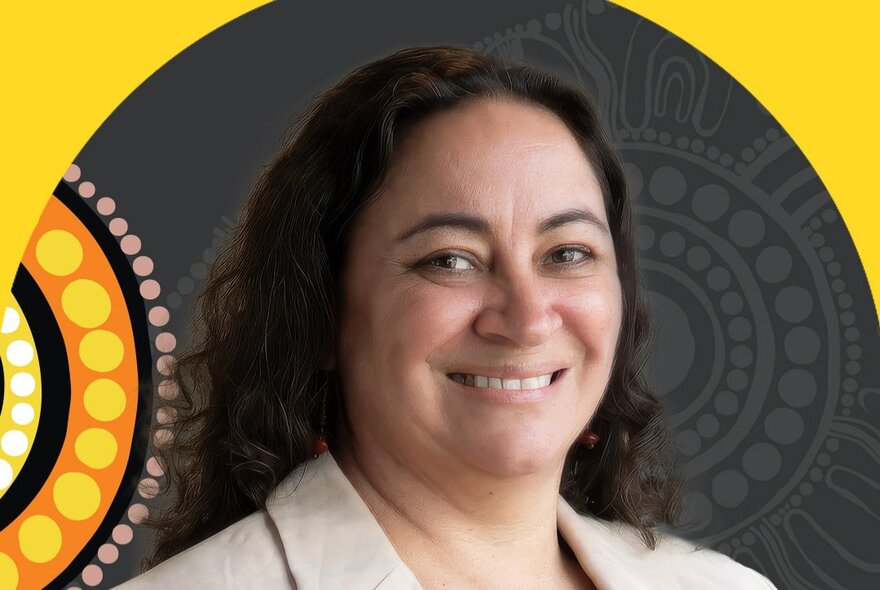 Headshot of a smiling woman with dark, curly hair wearing a light-colored blazer, positioned in front of a background that includes a yellow circular motif.