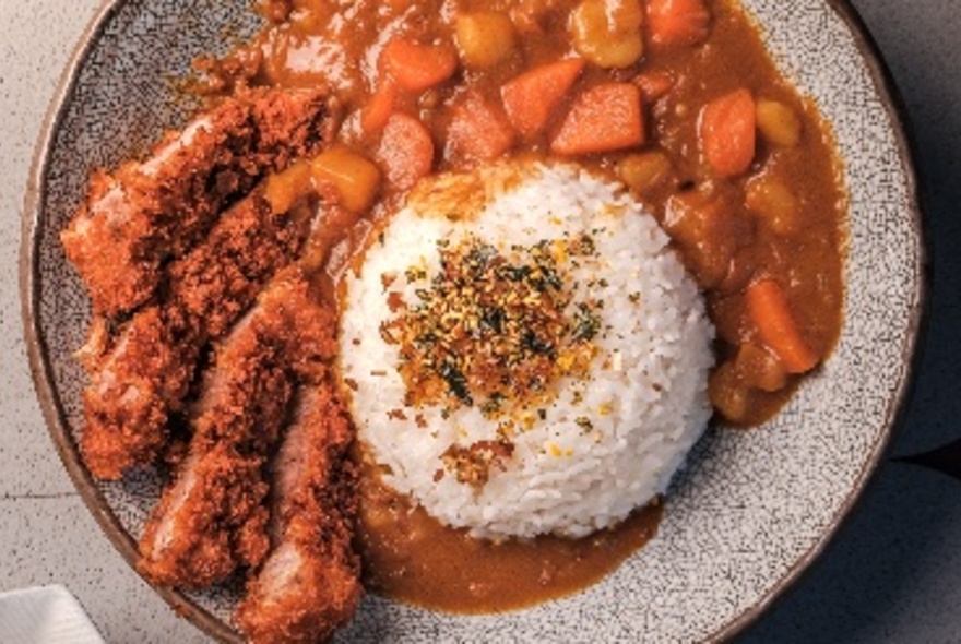 Looking down on a plate of Tonkatsu curry and rice.