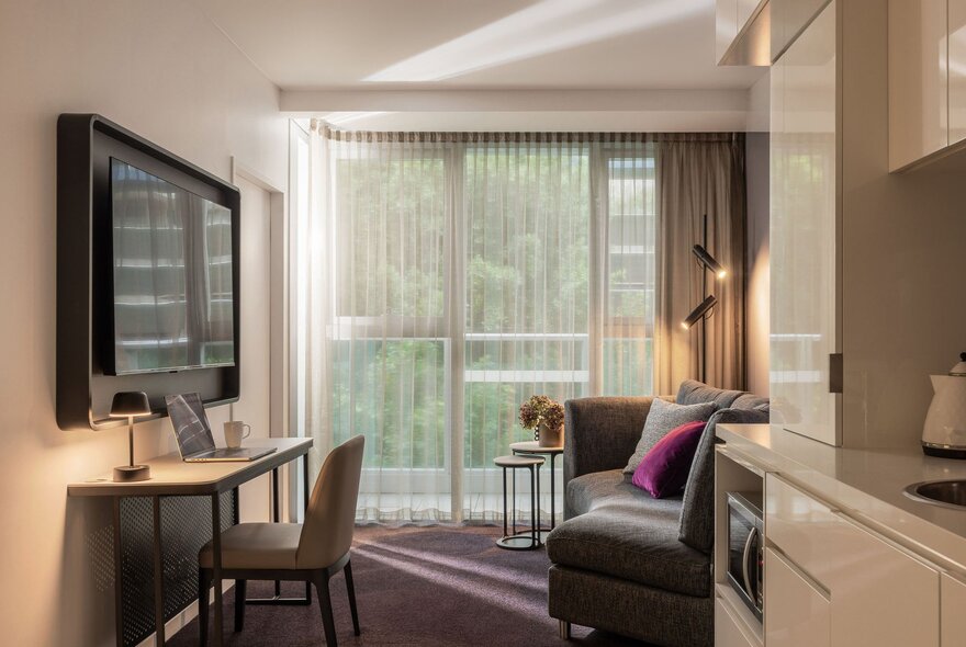 Sebel Docklands hotel apartment with a tv on the wall and a kitchenette.