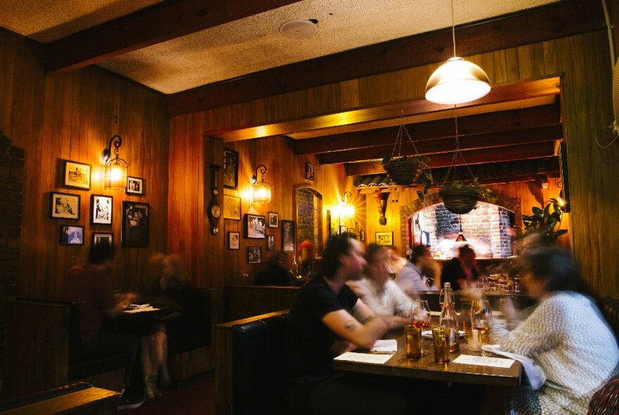 A group of people are sitting in a dimly lit restaurant