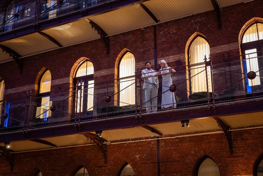 Inside the InterContinental hotel showing two people standing on a balcony. 