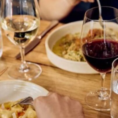 A table set with pasta and wine.