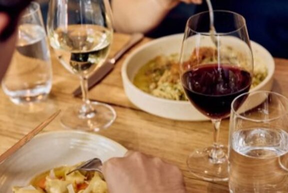 A table set with pasta and wine.