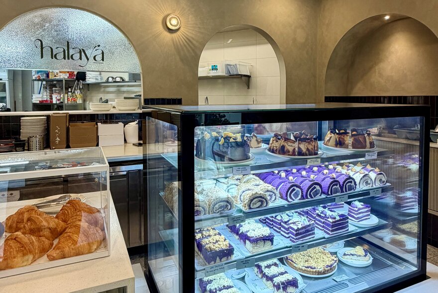 Display case of pastries, cakes and tarts in a cafe setting.