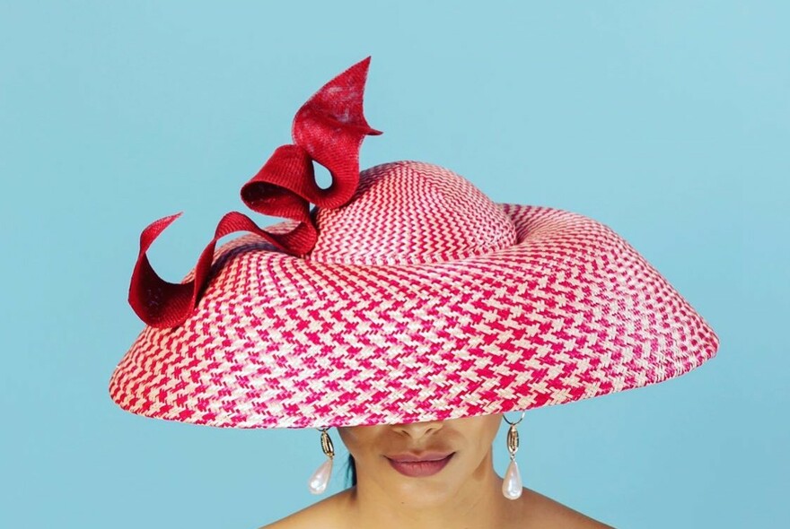 Woman in striking red and white pattered hat.