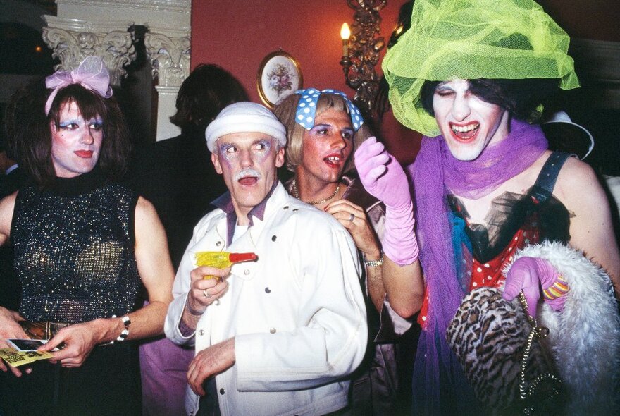 People in drag at a gathering, mingling and having fun. 