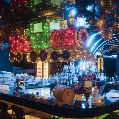 Bar decorated with Christmas lights and a train decoration.