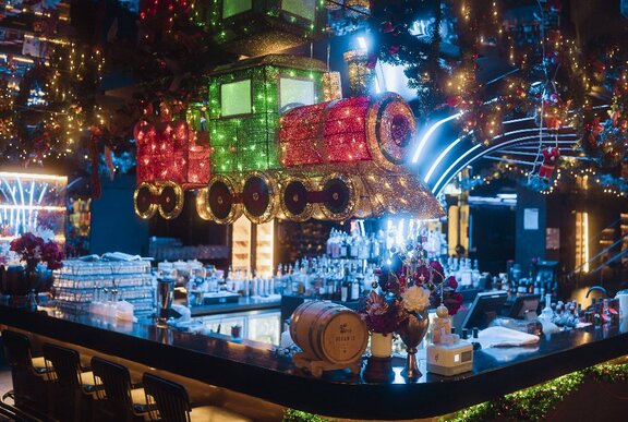 Bar decorated with Christmas lights and a train decoration.