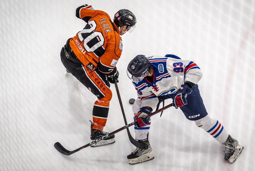 An ice hockey match with two players competing against each other. 