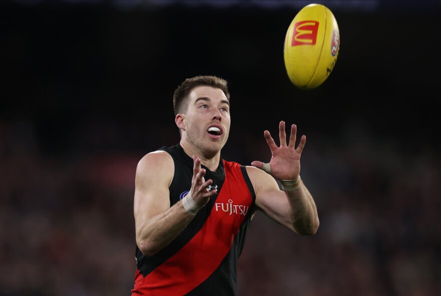 Essendon AFL football player catching a ball.