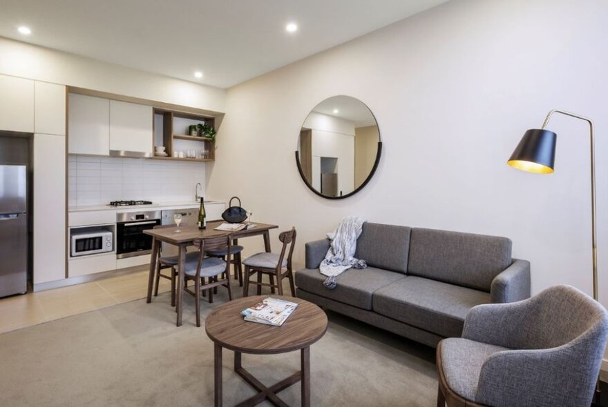 Hotel room with lounge seating and kitchen area with sofa.