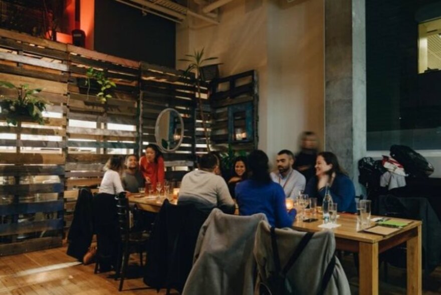 People seated at a long table in a restaurant.