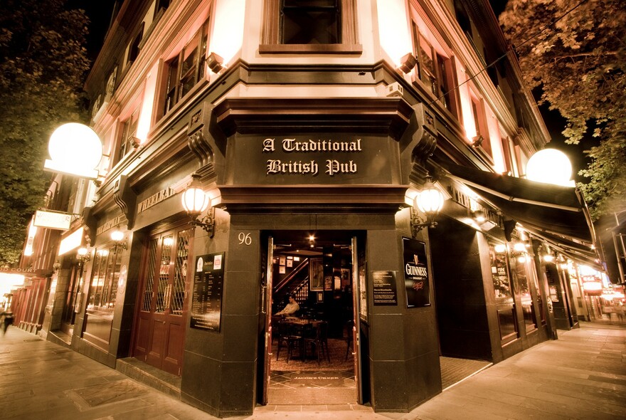 Street view of a traditional English pub building at night.