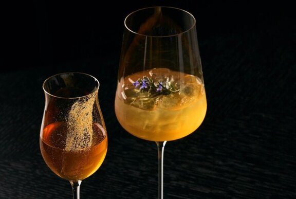 Two cocktails in different shaped glass, against a black background.