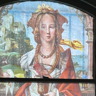 Renaissance-style painting of a woman screened onto a window frame.