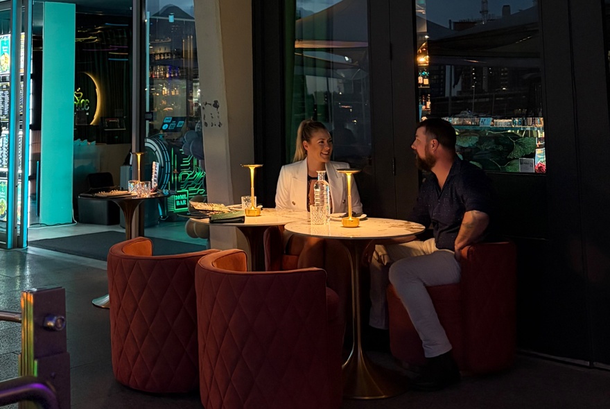 Diners seated at spotlight tabless with rounded seating.