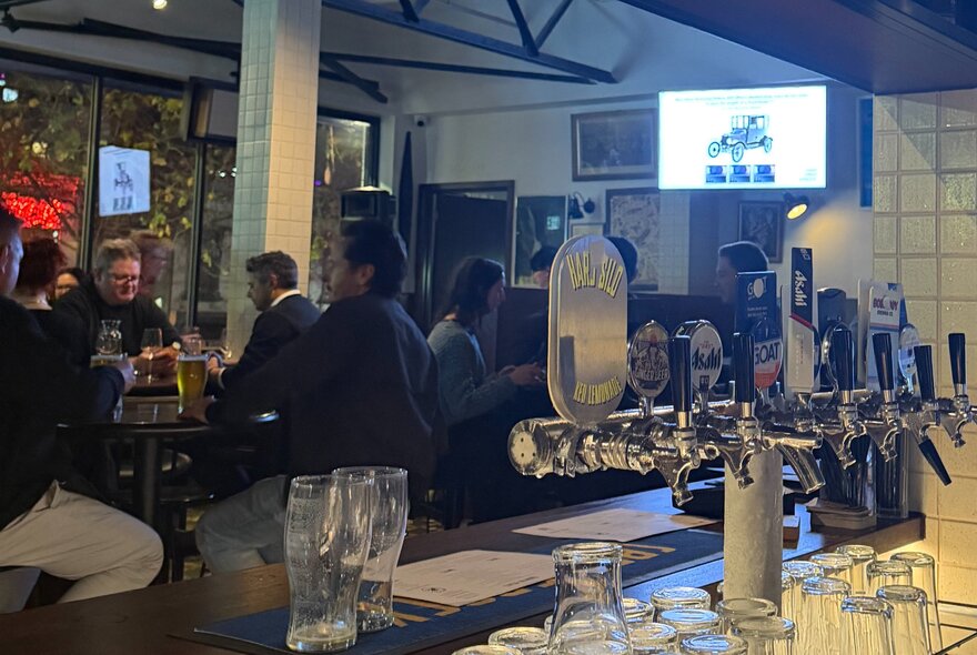 A crowd of people seated at tables inside Springrock Public Bar enjoying drinks and dining, taking part in a trivia quiz.