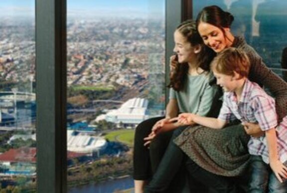 A mother cuddles her two kids while on the Melbourne Skydeck, high above the city. 