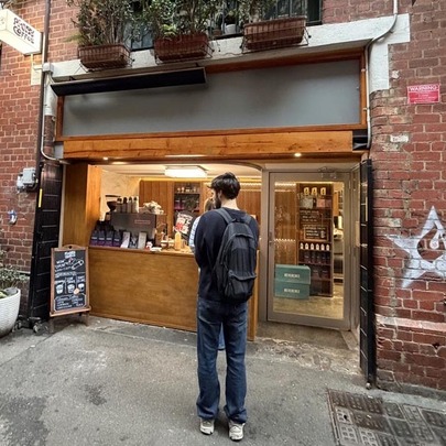 A man ordering from a  laneway coffee window. 