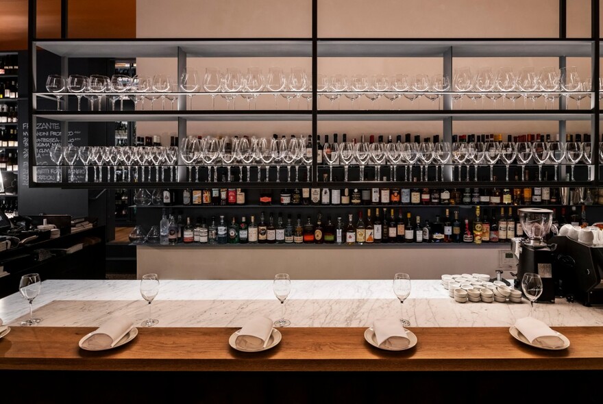 Table set with wine bottles and glasses in the background. 