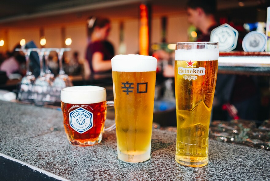 Selection of beers in glasses standing on the bar.