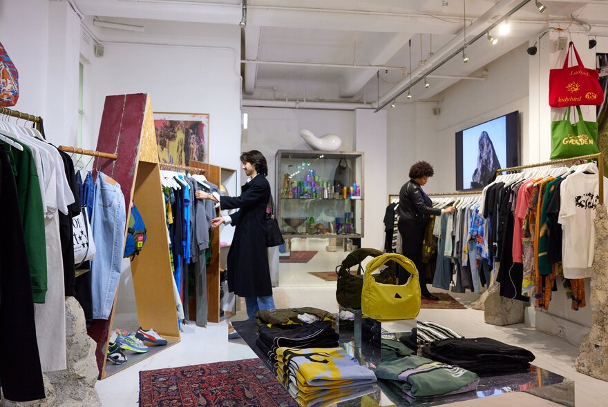 Two friends are browsing clothes in a clothing store.
