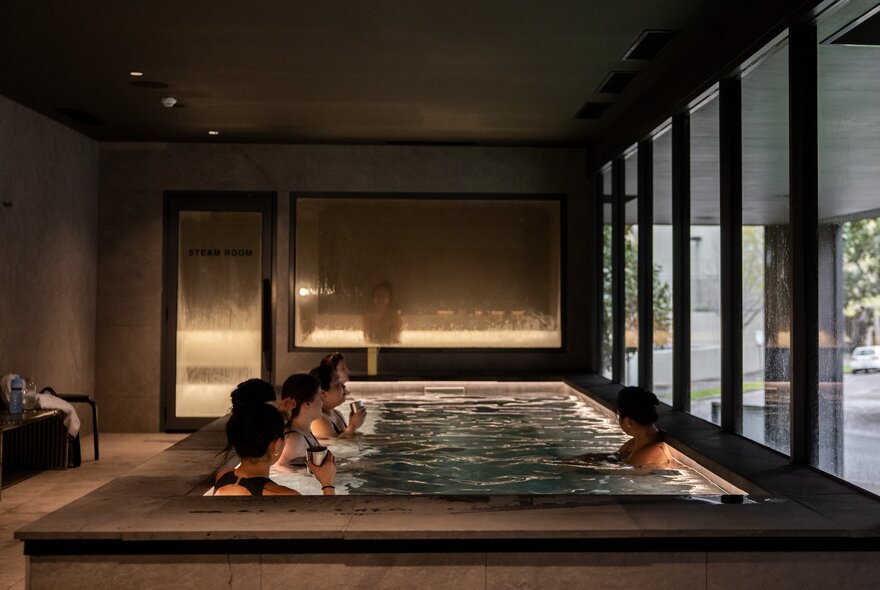 People having a group dip in a bathhouse. 