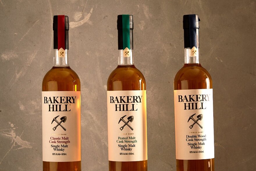 Three bottles of branded BAKERY HILL whisky arranged in a row.