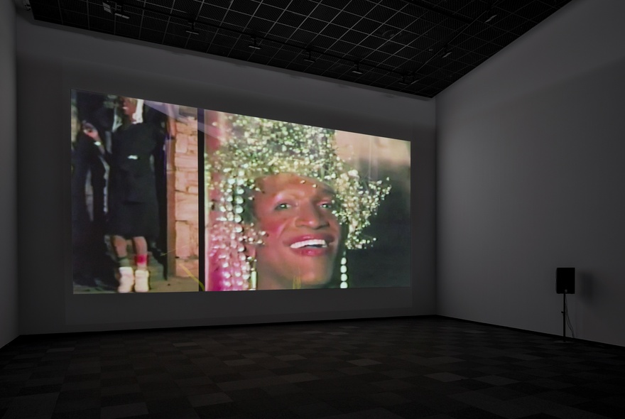 A digital projection of a person wearing makeup and a baby's breath wreath, next to a photo of a person wearing black.