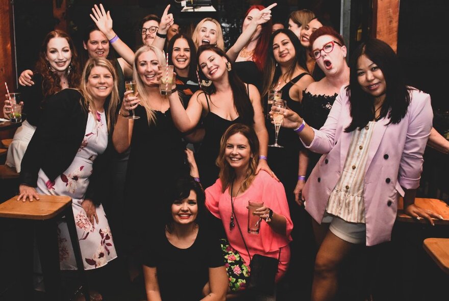 A big group of women celebrating New Year's Eve together with glasses of champage.